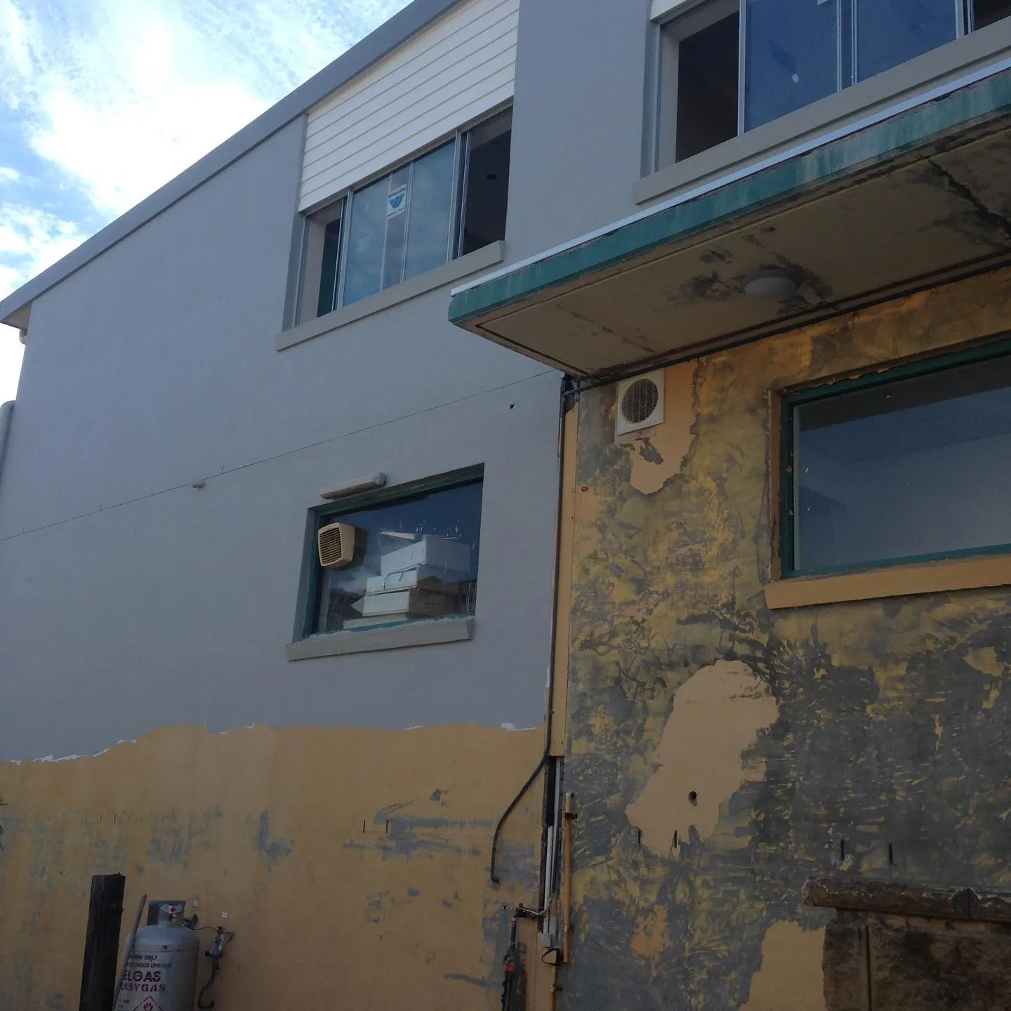 Apartment facade being stripped and prepared for rendering