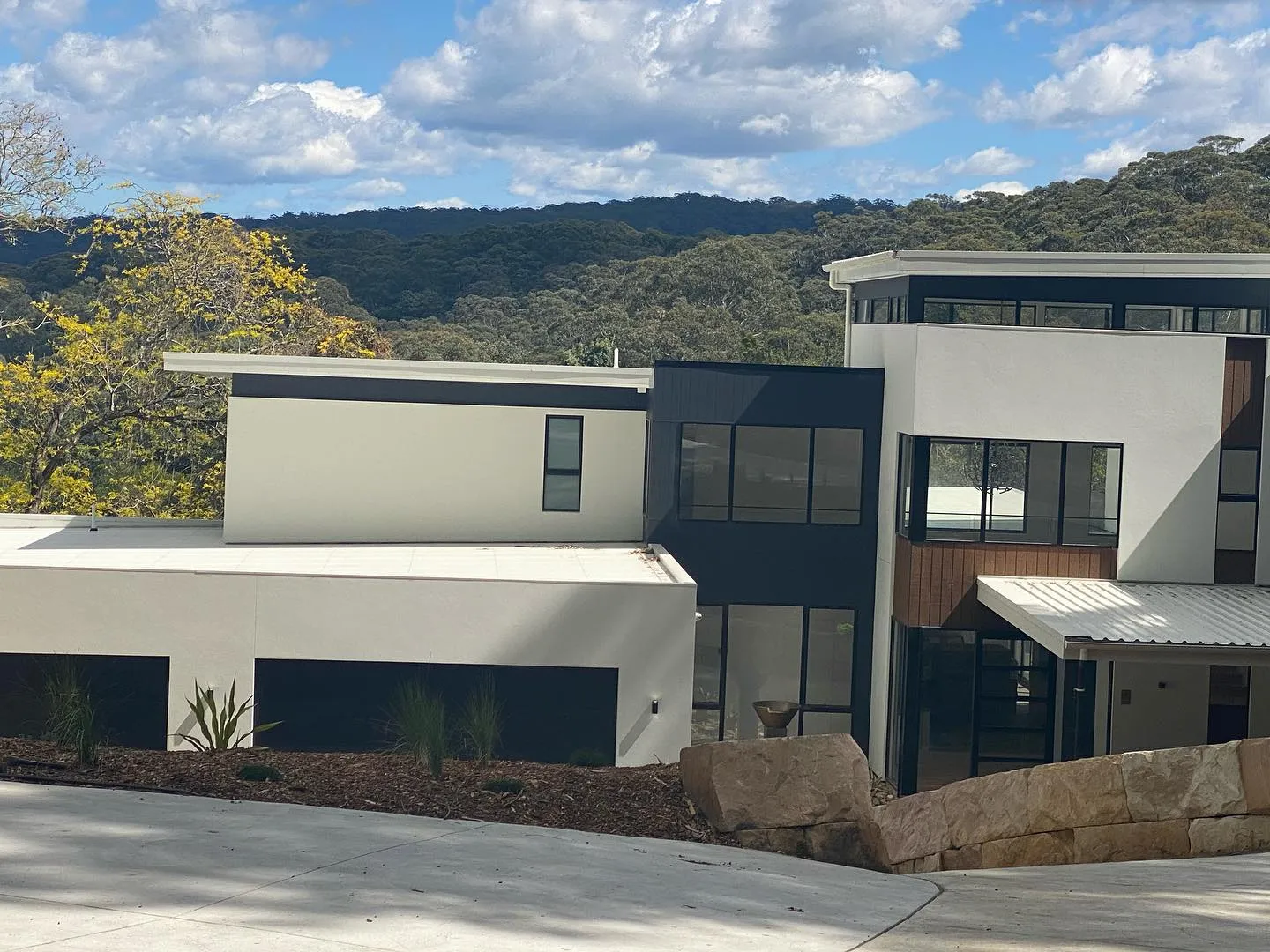 Modern two-storey rendered home against a bushland ridge, finished by J Mears Rendering