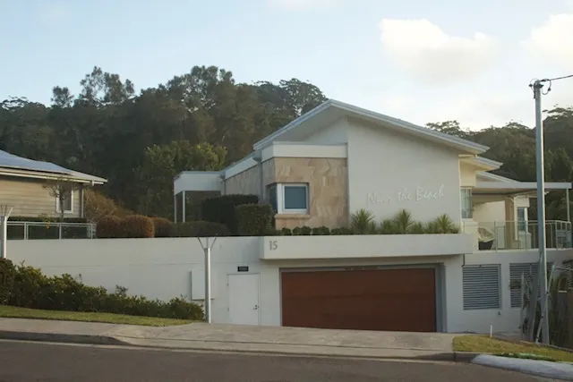 Rendered beachside home with crisp white walls and sandstone feature panel