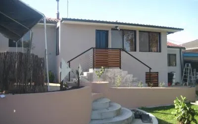 Rendered home exterior with fresh white walls and rendered garden retaining walls