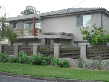 Rendered two-storey Erina home with a textured grey finish and front fence