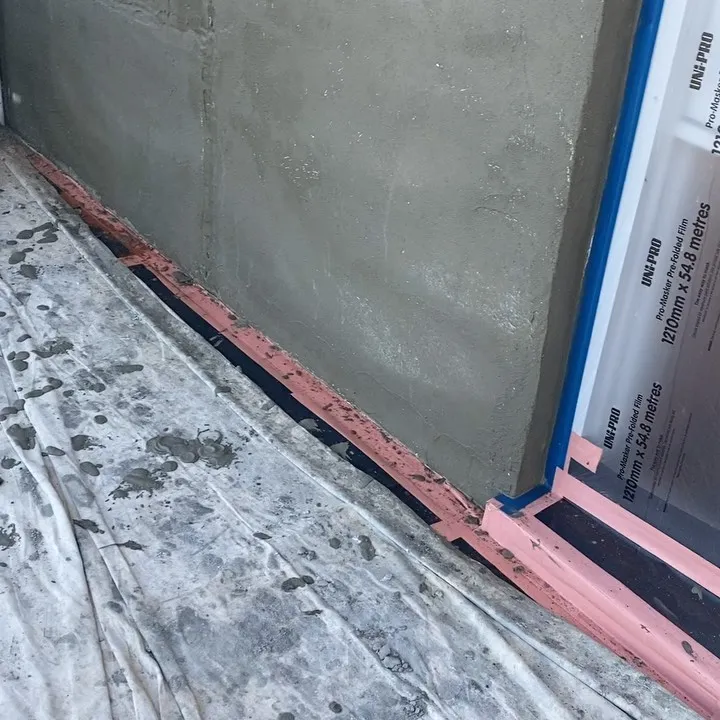 Foam board render system installed at the base of a new wall